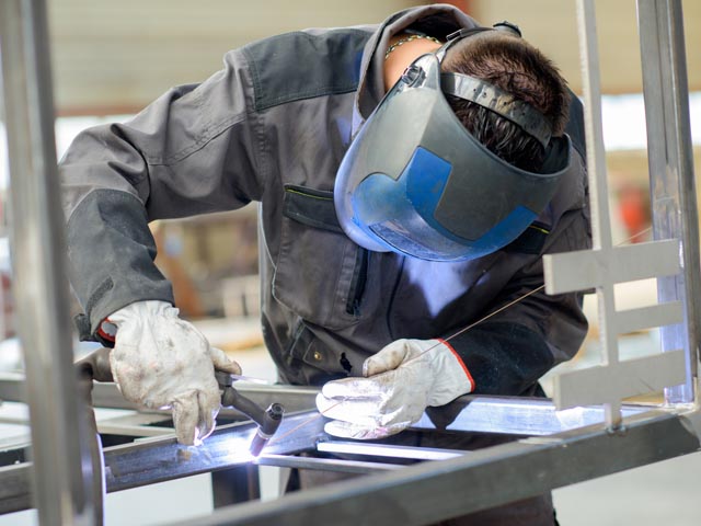 Man leaning over welding